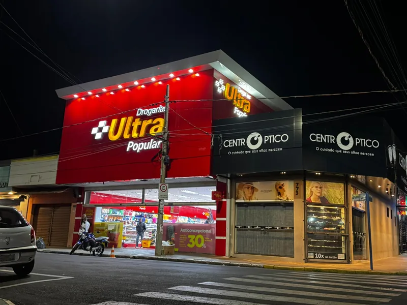 Fachadas iluminadas da Drogaria Ultra e Centro Óptico